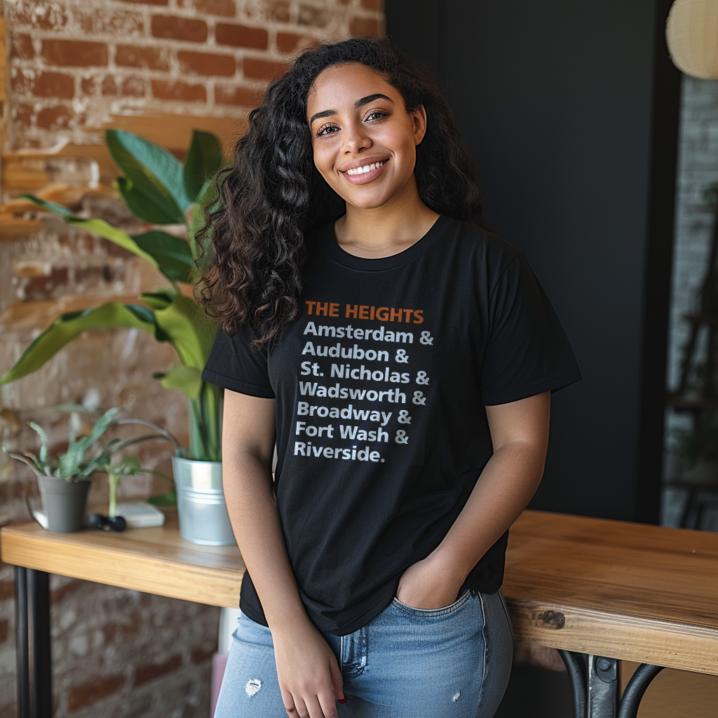 Beautiful Dominican girl smiling wearing an oversized Bella Canvas 3001 graphic tshirt with the words "The Heights Amersterdam & Audubon & St. Nicholas & Wadsworth & Broadway & Fort Wash & Riverside." on the front