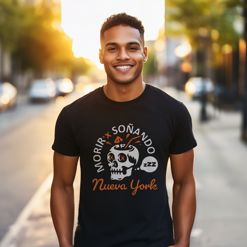 Good looking Dominican papi wearing an oversized Bella Canvas 3001 graphic tshirt with a skull drink and the words "Morir Soñando Nueva York" on the front