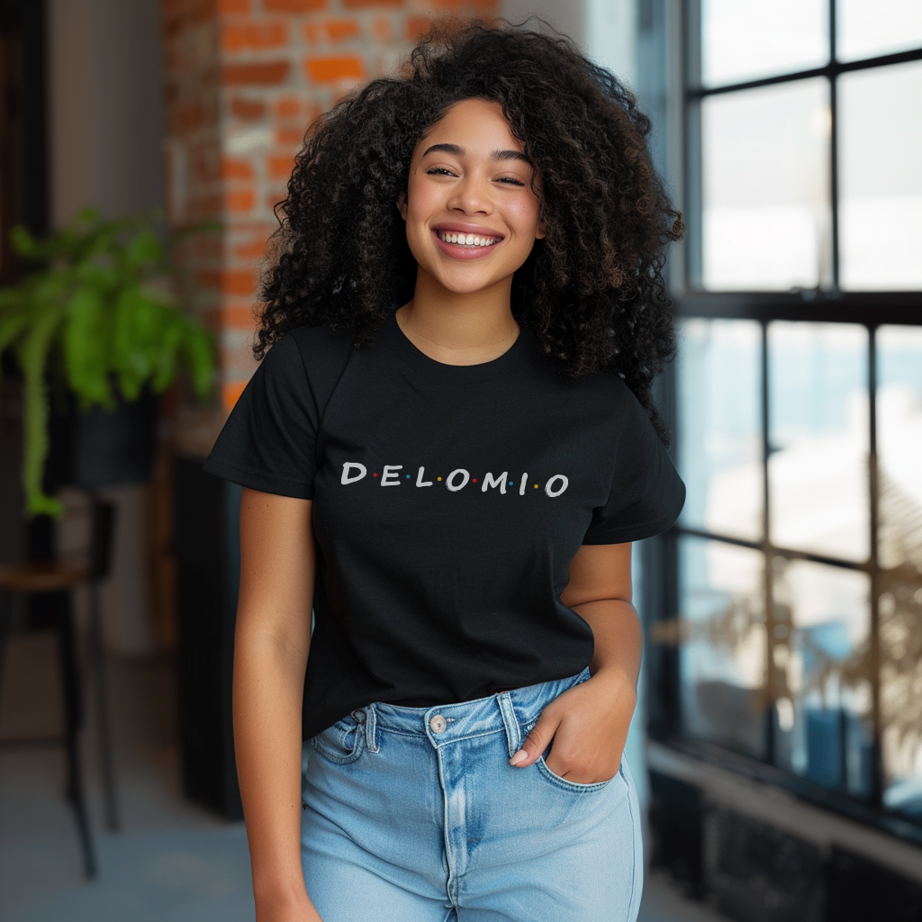 Pretty Dominican girl smiling wearing an oversized Bella Canvas 3001 graphic tshirt with the words "De Lo Mio" a Parady of the Friends TV Show font